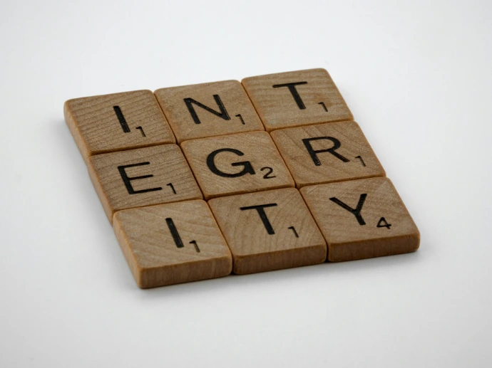 a scrabbled wooden block with the words integr city on it